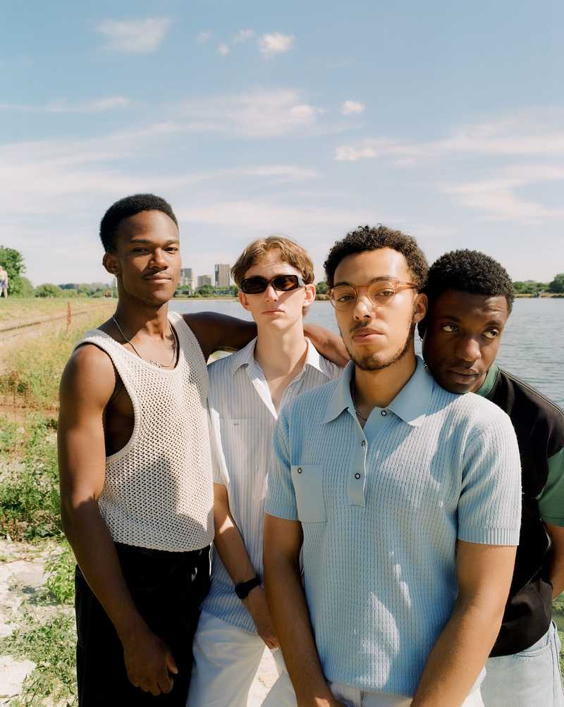 Malady, a group of four men stood in a field, film photo with soft warm colours
